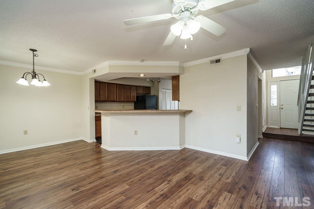 7906 Falcon Rest Circle Raleigh, NC 27615 - Photo 4 of 20 a view of a kitchen with wooden floor and a ceiling fan