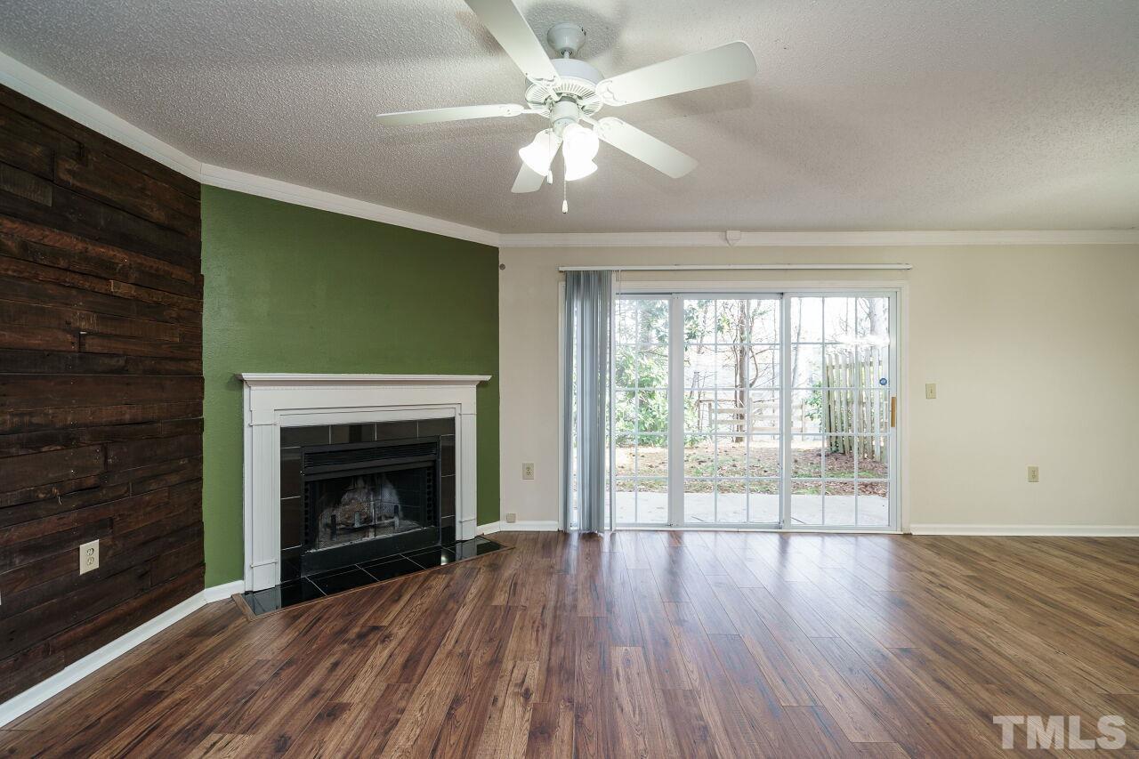 7906 Falcon Rest Circle Raleigh, NC 27615 - Photo 5 of 20 a view of an empty room with wooden floor fireplace and a window