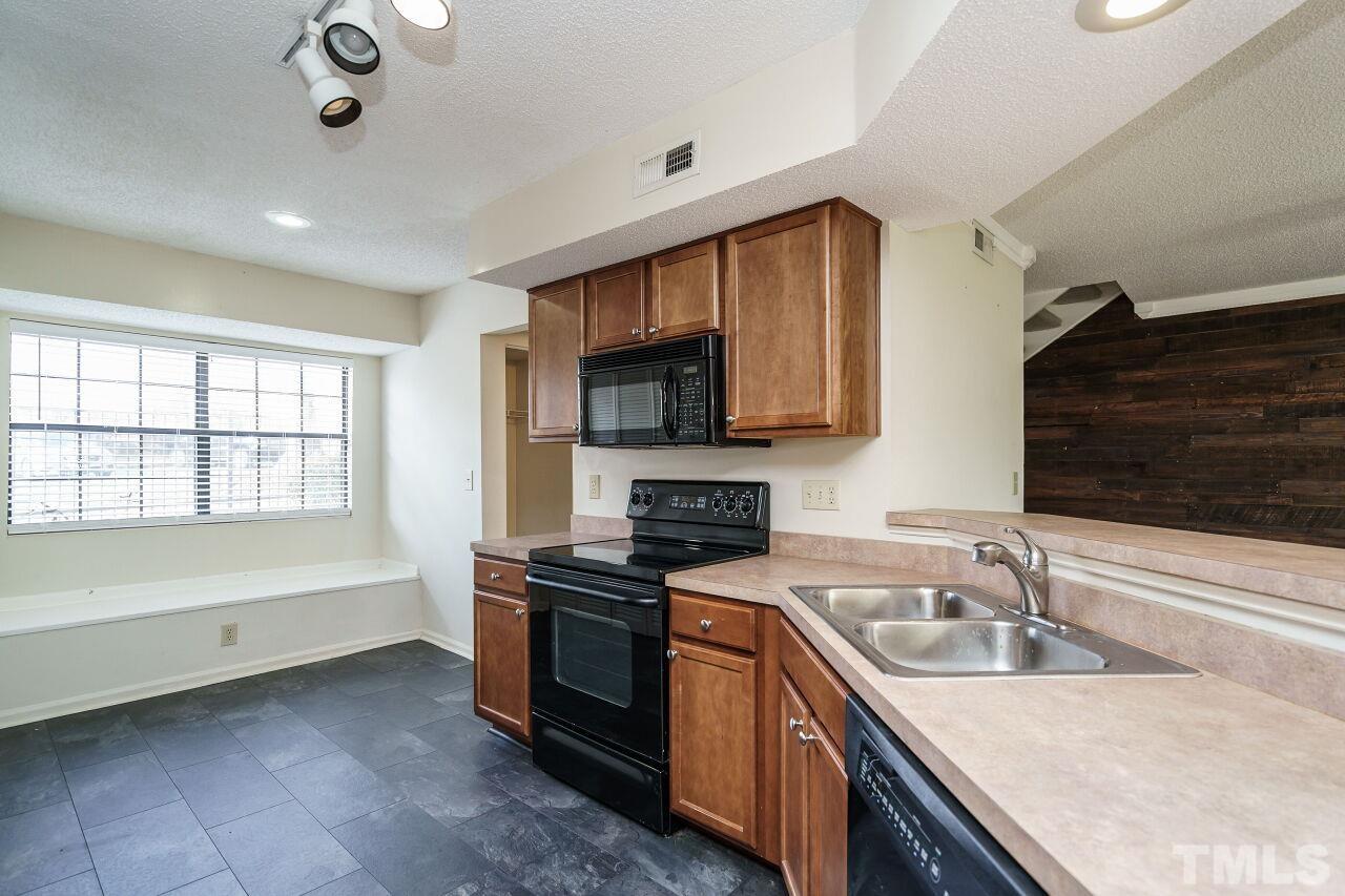 7906 Falcon Rest Circle Raleigh, NC 27615 - Photo 8 of 20 a kitchen that has a sink and a stove in it