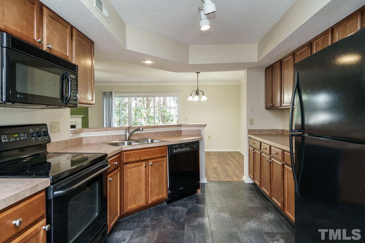 7906 Falcon Rest Circle Raleigh, NC 27615 - Photo 9 of 20 a kitchen with stainless steel appliances granite countertop a stove a sink and a microwave