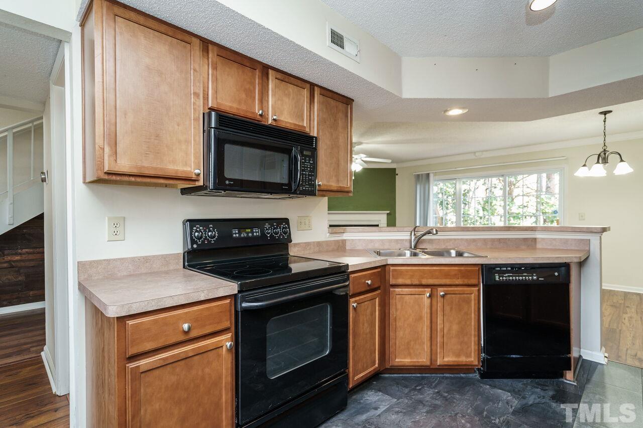 7906 Falcon Rest Circle Raleigh, NC 27615 - Photo 10 of 20 a kitchen with a sink stove and microwave