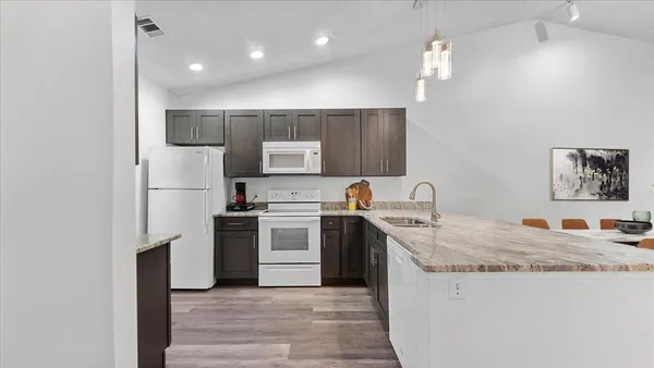 a kitchen with stainless steel appliances granite countertop a sink stove and refrigerator