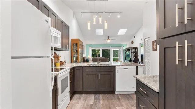 a view of kitchen with stainless steel appliances granite countertop cabinets and wooden floor