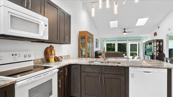 a kitchen with a sink refrigerator and window