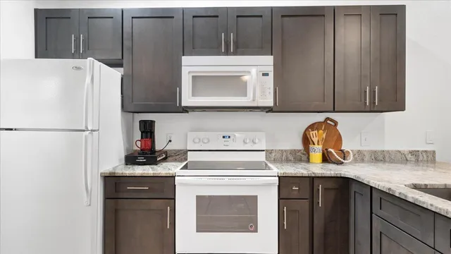 a kitchen with granite countertop a sink stainless steel appliances and cabinets