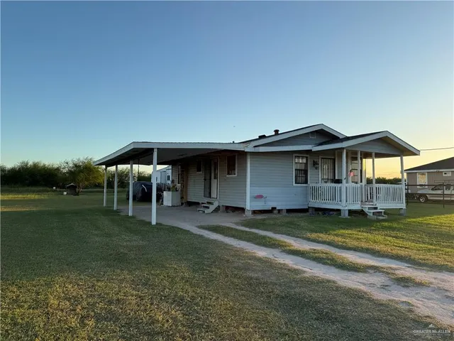 a view of a house with backyard and sitting area
