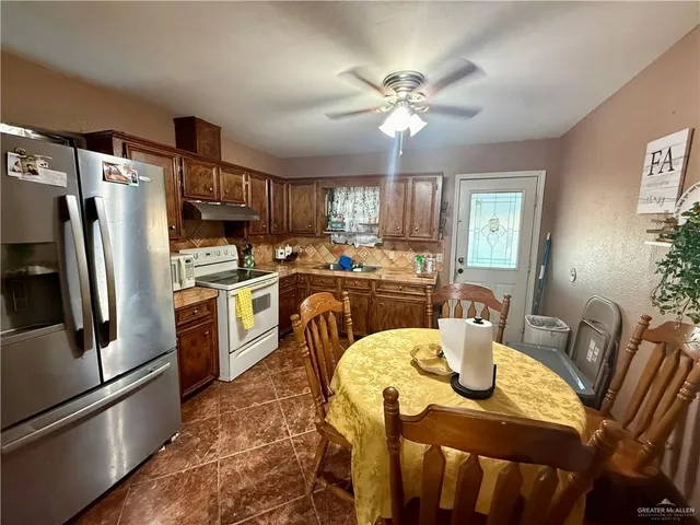 a view of a dining room with furniture a kitchen and chandelier