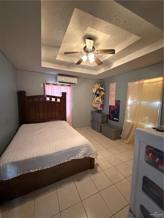 233 Buena Tierra Street Donna, TX 78537 - Photo 9 of 11 a bedroom with a bed and a chandelier