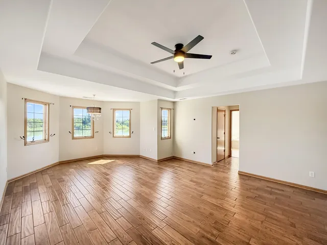 a view of empty room with wooden floor and window
