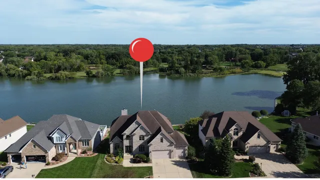 an aerial view of a house with a yard and lake view