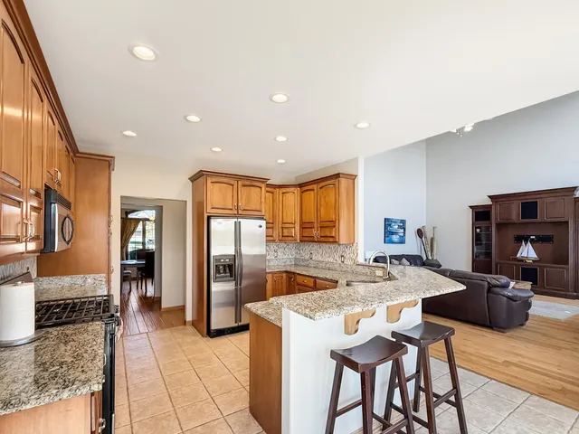 a kitchen with stainless steel appliances granite countertop a refrigerator and a stove top oven