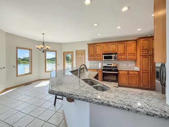 a kitchen with stainless steel appliances granite countertop a sink stove and cabinets
