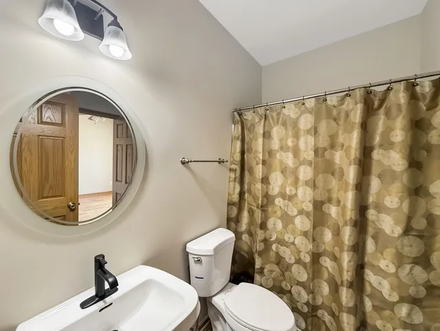 a bathroom with a toilet a sink and a mirror