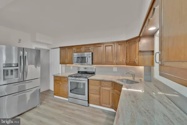 a kitchen with stainless steel appliances granite countertop a stove a sink and a refrigerator