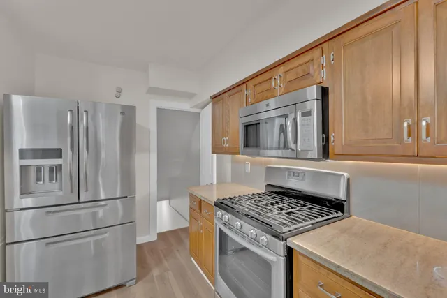a kitchen with stainless steel appliances granite countertop a refrigerator and a stove top oven