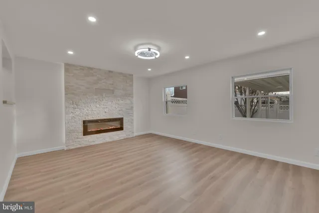 an empty room with wooden floor and fireplace