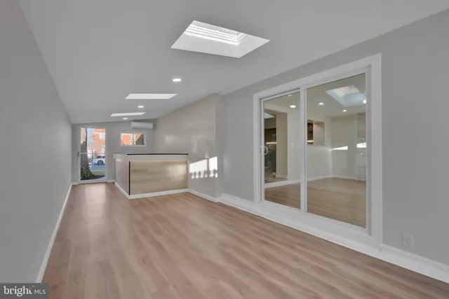 a view of a hallway with wooden floor and a living room