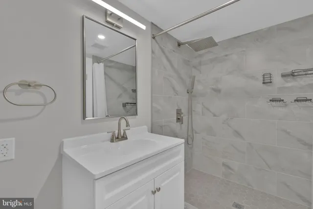 a bathroom with a sink shower and a mirror