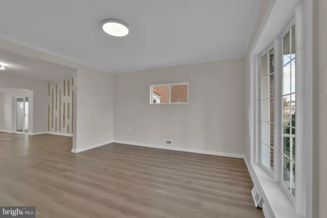 a view of an empty room with wooden floor