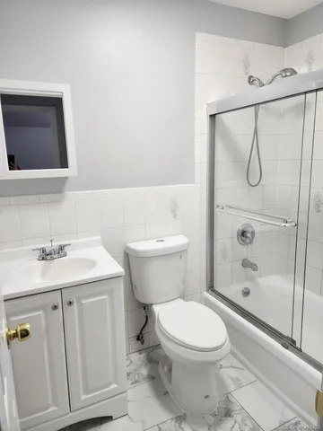 a bathroom with a toilet sink vanity shower and mirror