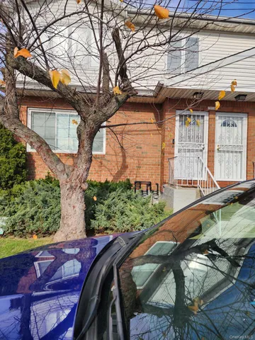 a view of a house with a large tree and a yard