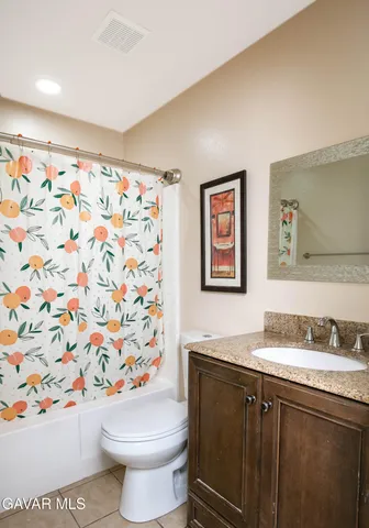 a bathroom with a granite countertop sink and a toilet