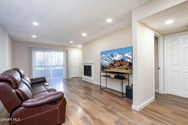 a living room with furniture a wooden floor and a fireplace