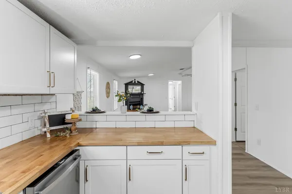 a view of a kitchen with kitchen island a sink wooden floor and counter top space