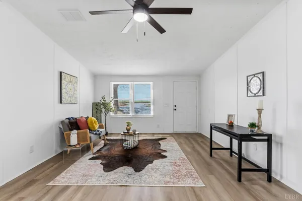 a living room with furniture and a wooden floor