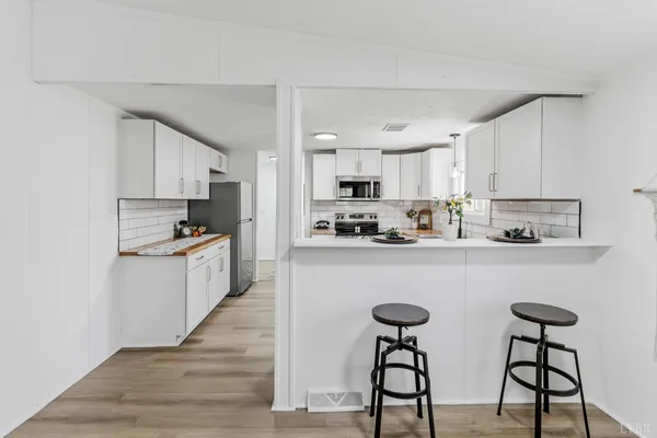 a kitchen with granite countertop white cabinets and appliances