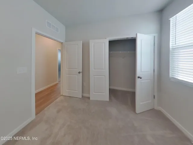 an empty room with windows and closet