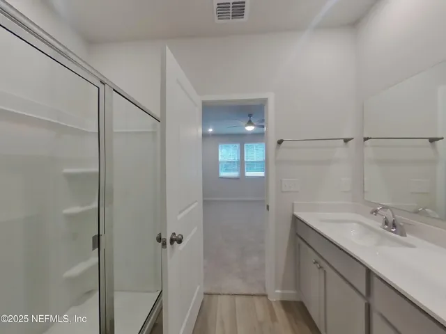 a bathroom with a shower sink and mirror