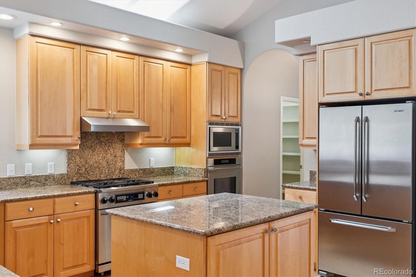 981 Sleepy Hollow Road Golden, CO 80401 - Photo 16 of 50 a kitchen with stainless steel appliances granite countertop a refrigerator a sink and white cabinets
