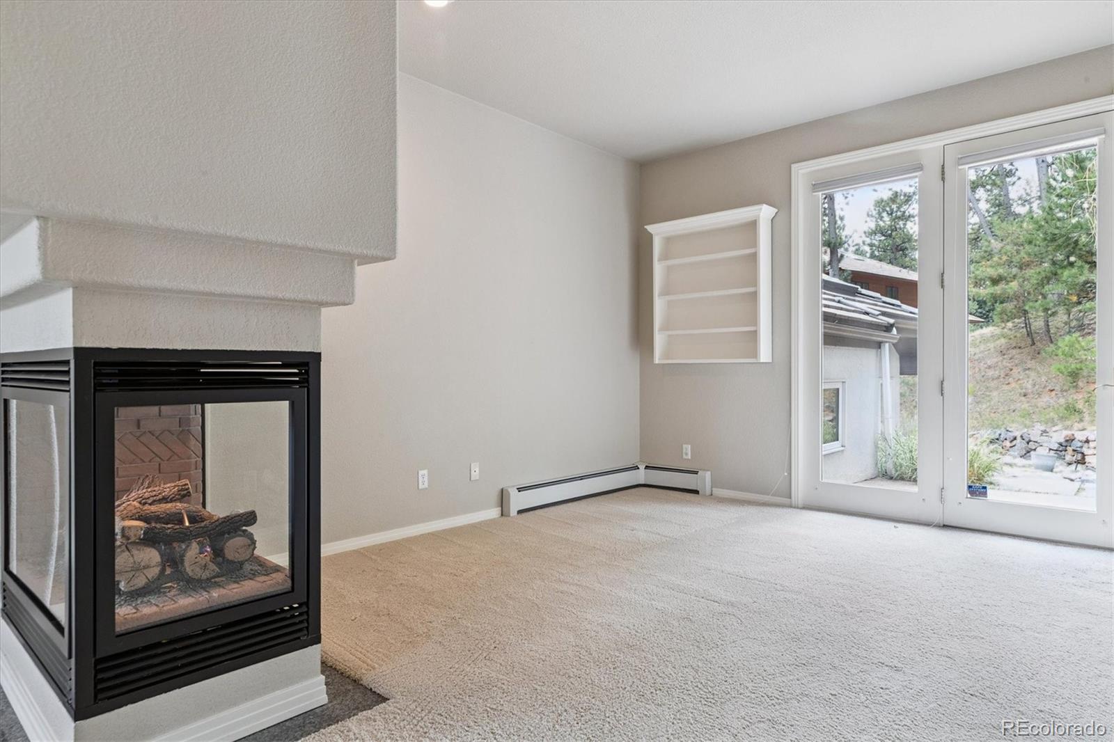 981 Sleepy Hollow Road Golden, CO 80401 - Photo 22 of 50 a view of an empty room with a fireplace and a window