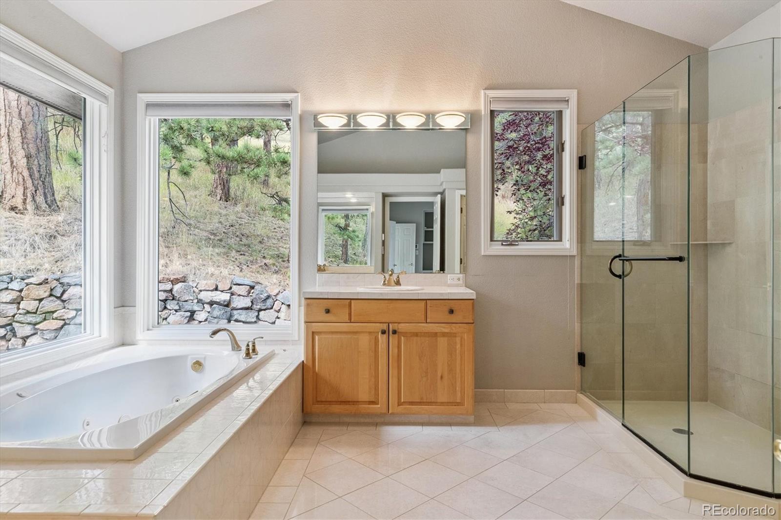 981 Sleepy Hollow Road Golden, CO 80401 - Photo 23 of 50 a bathroom with a tub sink and mirror