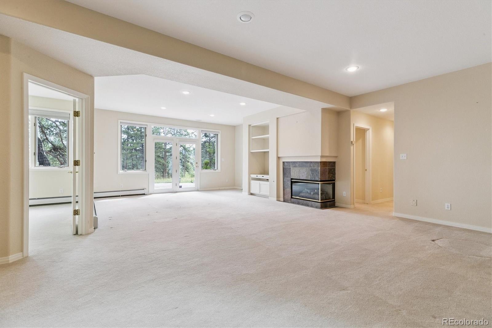 981 Sleepy Hollow Road Golden, CO 80401 - Photo 31 of 50 a view of an empty room with a fireplace and a large window