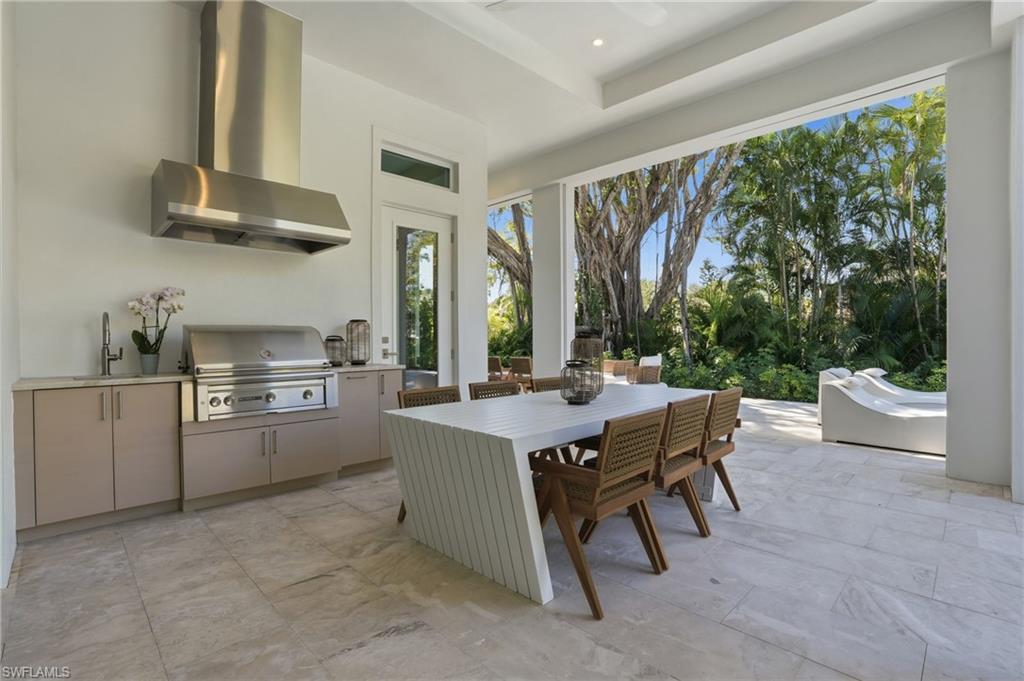 4851 Crayton Road Naples, FL 34103 - Photo 28 of 33 a kitchen with a stove a refrigerator and a table