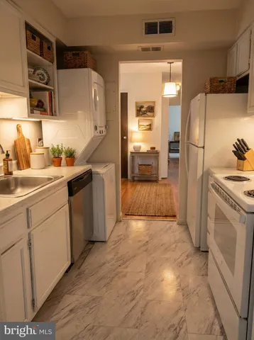a kitchen with a sink a refrigerator and cabinets
