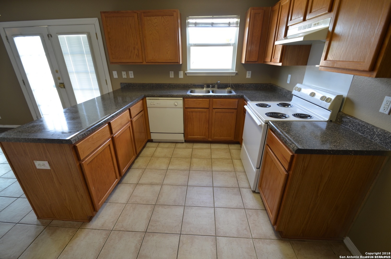 9139 Laguna Selma, TX 78154 - Photo 4 of 10 a kitchen with a sink a stove top oven a refrigerator and window