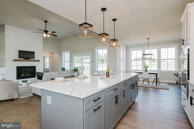 a kitchen with stainless steel appliances granite countertop a stove a sink and white cabinets
