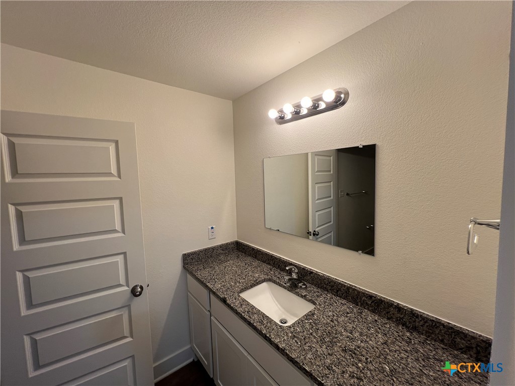 1822 Royal Loop Belton, TX 76513 - Photo 12 of 22 a bathroom with a granite countertop sink and a mirror