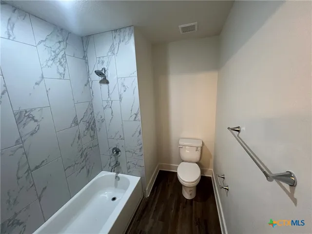 a bathroom with a granite countertop bathtub toilet and a sink