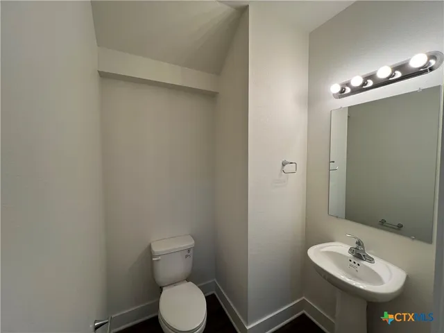 a bathroom with a toilet sink and mirror