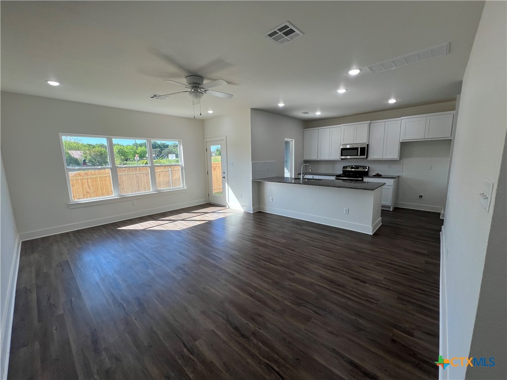 1822 Royal Loop Belton, TX 76513 - Photo 7 of 22 an open kitchen with kitchen island wooden floors and stainless steel appliances