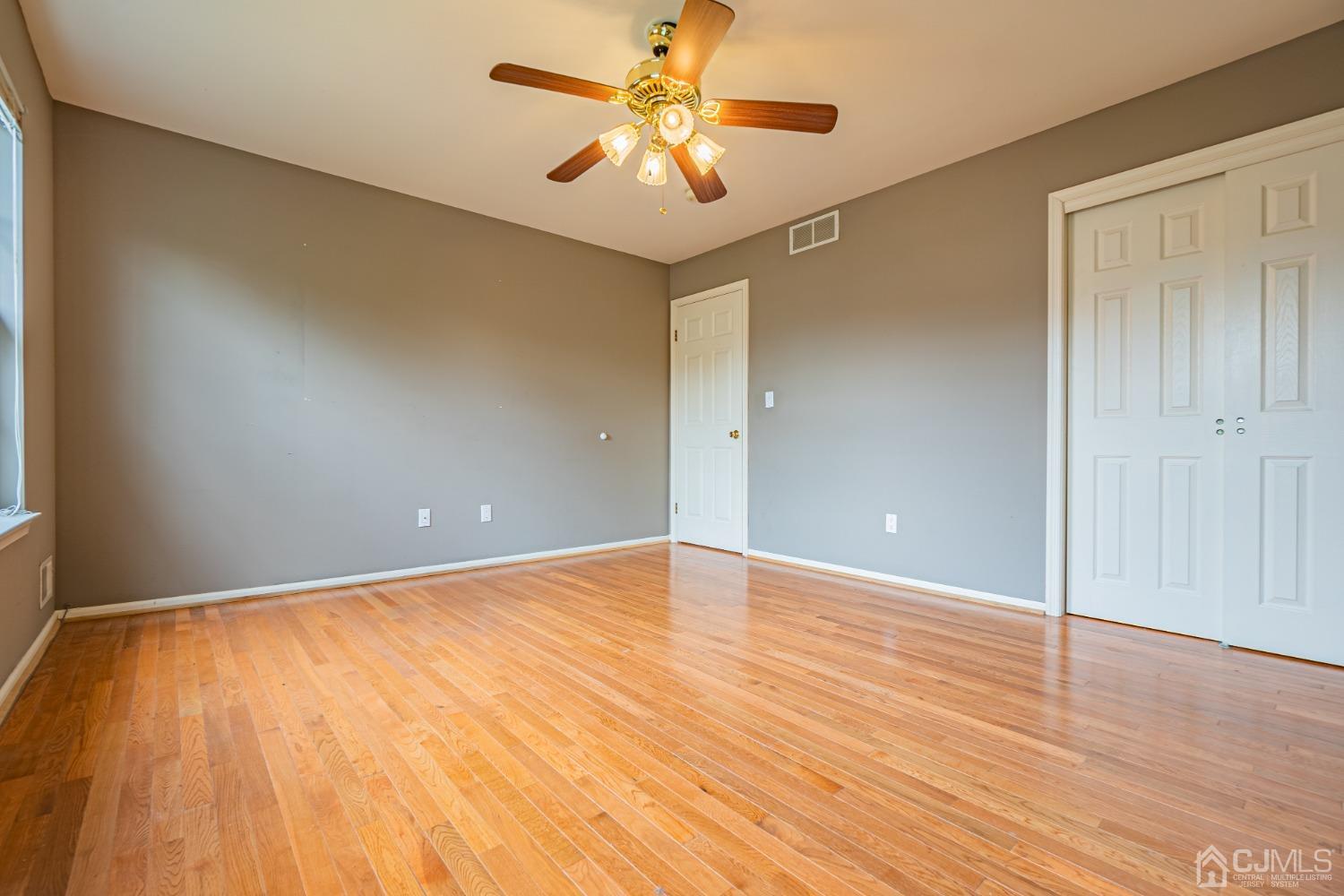 6 Sarah Court Edison, NJ 08817 - Photo 19 of 34 an empty room with wooden floor and a chandelier fan