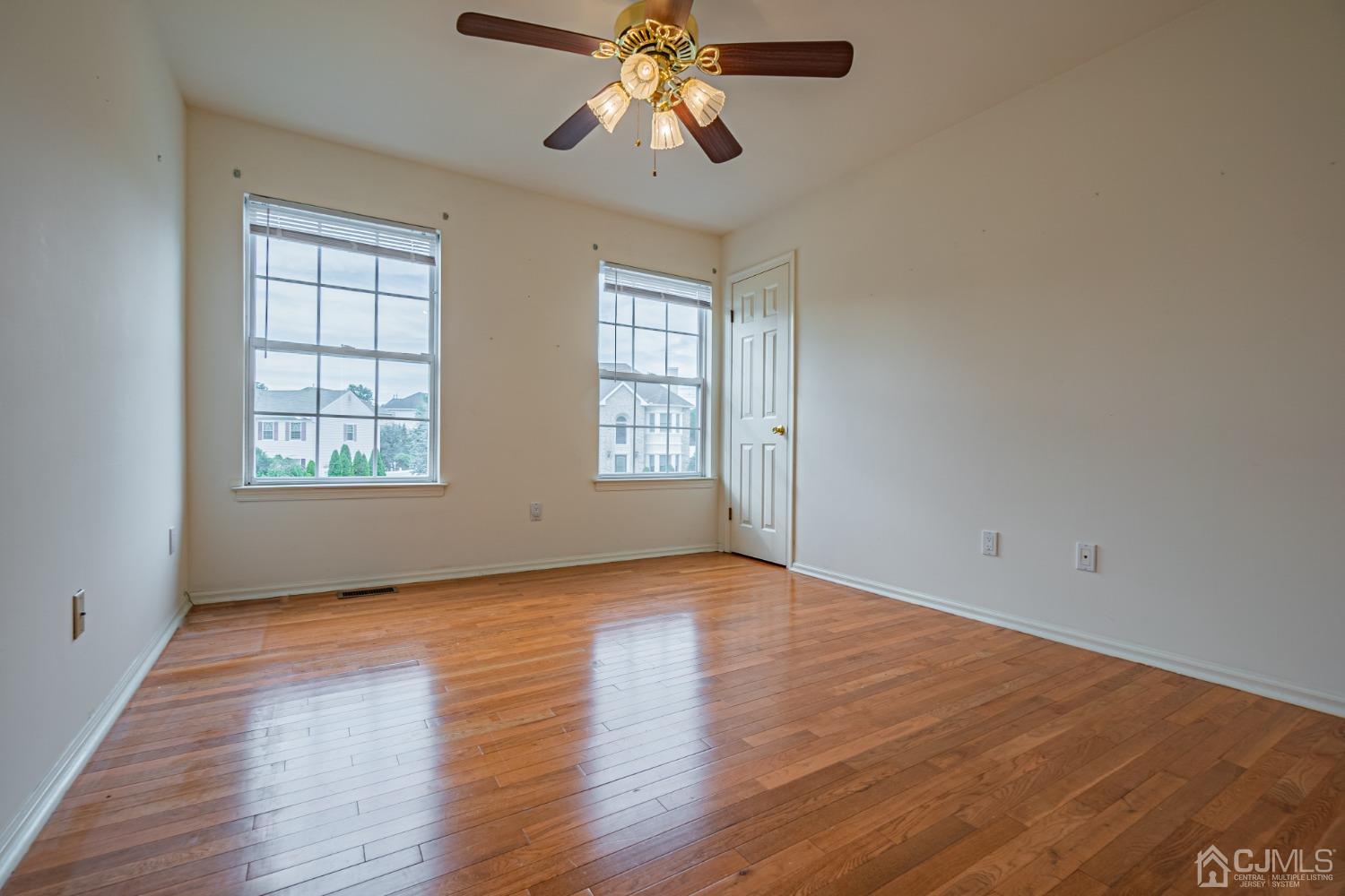 6 Sarah Court Edison, NJ 08817 - Photo 20 of 34 an empty room with wooden floor chandelier fan and windows