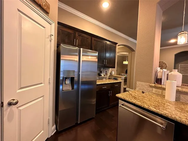 a kitchen with stainless steel appliances granite countertop a refrigerator and a sink