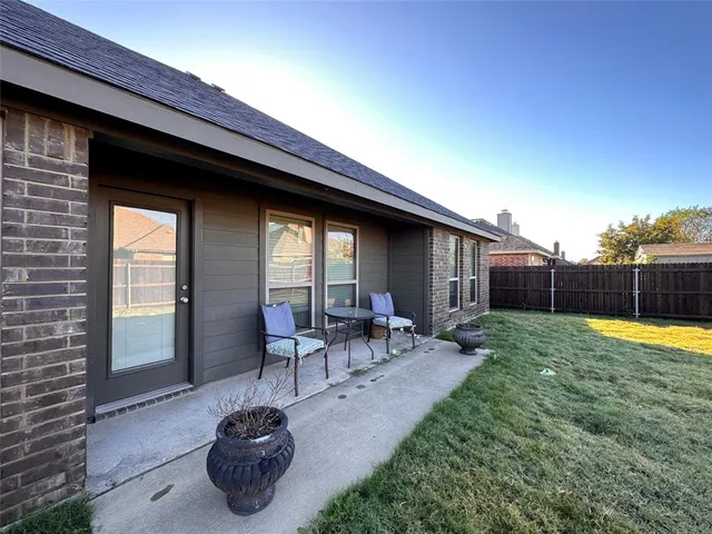 a backyard of a house with table and chairs