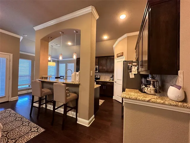 a kitchen with stainless steel appliances granite countertop sink stove and wooden floor