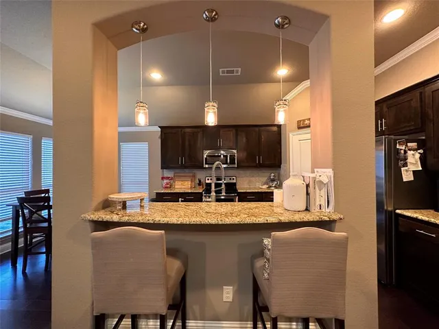 a kitchen with a dining table chairs sink and cabinets